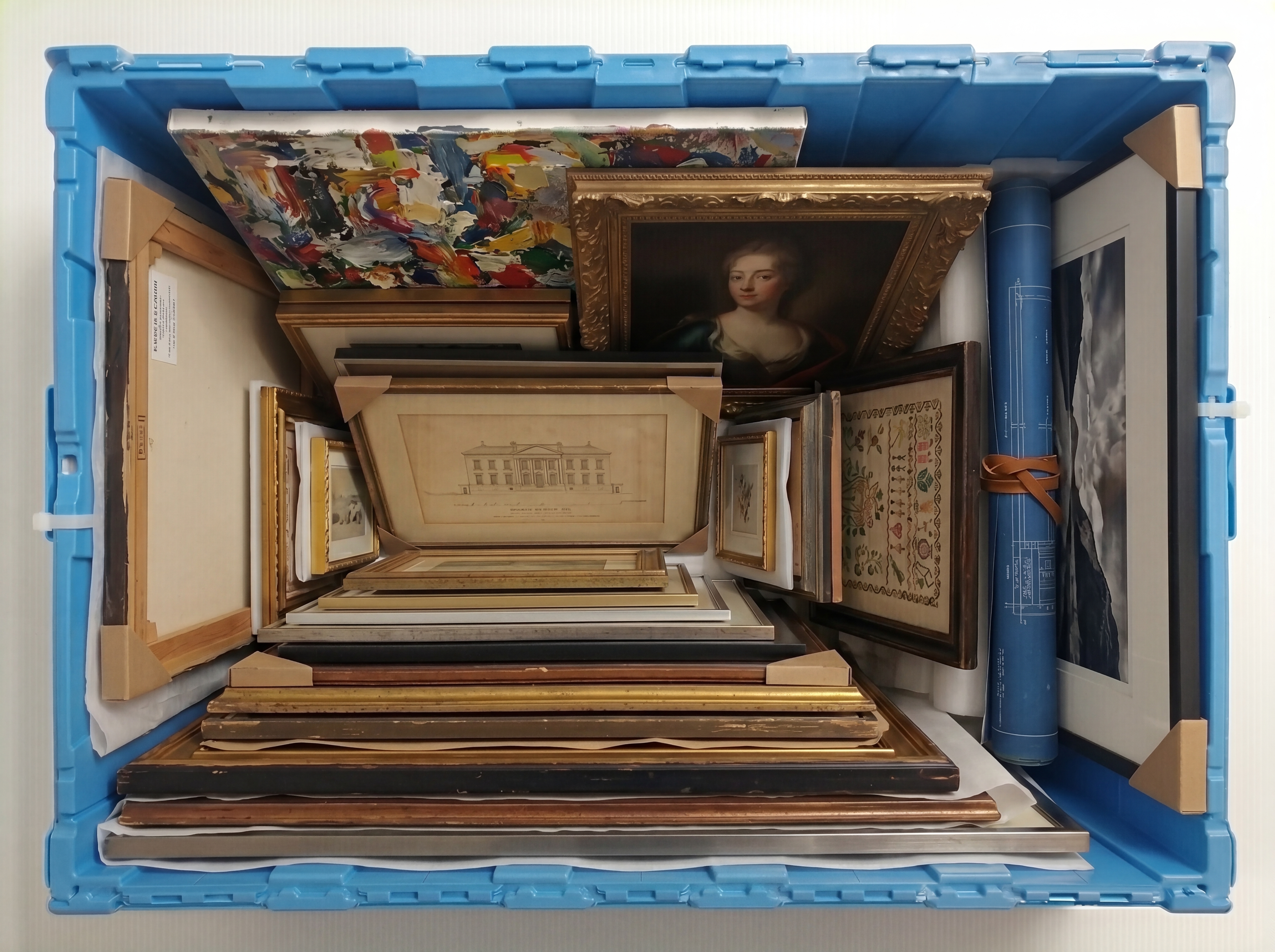 Paintings and frames stored in a large Fort Lox box